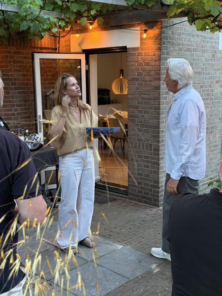 This photo captures a relaxed evening gathering on a patio at Koetlaan, Vogelwijk, Den Haag